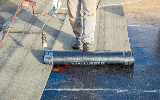 Flat roof installation. Heating and melting bitumen roofing felt.